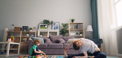 a man and a child playing on a rug in a living room